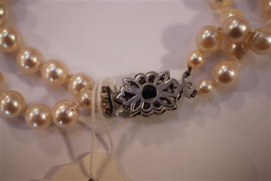 A double strand cultured pearl necklace with white gold, sapphire and diamond set clasp, 19.5in.